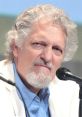 Clancy Brown speaks at a panel, showcasing his signature white hair and engaging presence. Actor known for diverse roles.