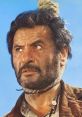 Eli Wallach portrays a rugged character with intense expression, set against a bright blue sky. Drama and tension captured.