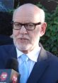 Frank Oz speaking at an event, wearing a suit and glasses, promoting his work in film and puppetry.