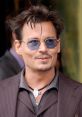 Johnny Depp sporting stylish sunglasses and a chic outfit, exuding charisma and charm at a public appearance.