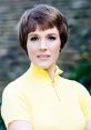 Portrait of Julie Andrews with short hair, wearing a yellow zip-up top, exuding classic 1960s elegance and charm.