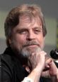 Mark Hamill smiling during a panel discussion, showcasing his iconic look and engaging personality.