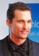 Matthew McConaughey smiles in a tuxedo, showcasing his signature style at a red carpet event. Elegant and charismatic.