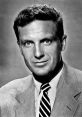 Black and white portrait of Robert Stack, showcasing his iconic 1950s style and distinguished facial features.