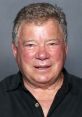 William Shatner smiles warmly in a casual black shirt, showcasing his charismatic presence and iconic status in entertainment.