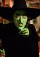 Wicked Witch casting a spell with a menacing grin, highlighted by her iconic green skin and pointed black hat.