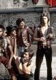 Iconic gang scene from "The Warriors" (1979); fierce characters in leather vests ready for action in a gritty urban setting.