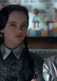 Wednesday Addams with braided hair, showing her iconic gothic style in a scene from "Addams Family Values.