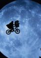 E.T. and Eliot soaring across the night sky on a bicycle against a glowing blue moon backdrop, capturing a magical moment.