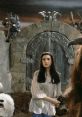 Sarah stands before the imposing gates in the world of "Labyrinth" (1986), surrounded by enchanting creatures and wonder.