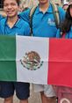 Group of smiling students holding the Mexican flag, showcasing national pride in Mexican culture and memes.