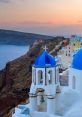 Sunset over Santorini's iconic blue-domed church, showcasing Greece's stunning coastal beauty and cultural charm.