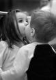 Two young children sharing a tender kiss, capturing the innocence and joy of love in a sweet moment of affection.