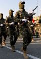 Militant soldiers in camouflage uniforms march in formation, showcasing military discipline and readiness during a war-themed parade.