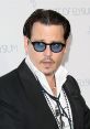 Johnny Depp at the Art of Elysium event, showcasing his distinctive style with sunglasses and elegant attire.