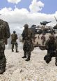 Soldiers in camouflage gear conduct a field operation near an armed vehicle in a rugged terrain setting.