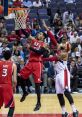 Player goes for a slam dunk in a high-energy basketball game, showcasing athleticism against a defender.