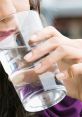 Woman enjoying a refreshing glass of cold water, promoting hydration and healthy drinking habits.