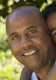 Smiling father enjoys quality time with his child outdoors, showcasing love and connection in a sunny setting.