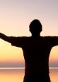 Silhouette of a person with outstretched arms against a serene sunset, symbolizing freedom and new beginnings.