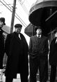 Four gangsters in classic black suits stand confidently on a city street, exuding vintage crime drama vibes.