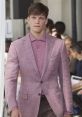 Stylish male model in a pink blazer and shirt, showcasing contemporary men's fashion on the runway.