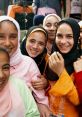 Smiling group of young girls in colorful clothing, showcasing joy and friendship in a vibrant market setting.