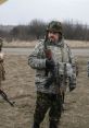 Ukrainian soldiers in camouflage uniforms discussing tactics while holding rifles in a military training environment.