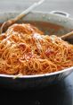 Delicious spaghetti tossed in a rich tomato sauce, served in a large pan, perfect for a hearty meal or gathering.