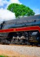 Streamlined steam locomotive 611 chugs along the tracks, showcasing its powerful design against a vibrant landscape.