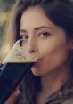 Woman enjoying a dark beverage, savoring the rich flavors and aroma, highlighting the art of drinking and refreshment.