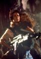 Ripley holds a child protectively while armed, embodying courage in a tense moment from "Aliens.