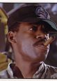 Sgt. Apone from Aliens, wearing a military cap, smoking a cigar, exuding confidence and leadership in a tense moment.