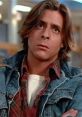 John Bender from The Breakfast Club with long hair, wearing a denim jacket, showing a contemplative expression.