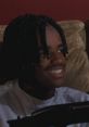 O Dog from Menace II Society smiles while gaming, showcasing his iconic braids and youthful energy in a pivotal scene.