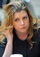 Penny Mordaunt deep in thought, showcasing a contemplative moment with soft curls and a black blazer in a public setting.