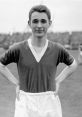 Young Brian Clough in football kit, smiling on the field, showcasing his early passion for the sport and future success.