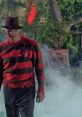 Freddy Krueger stalks through fog in a classic striped sweater, embodying horror from *A Nightmare on Elm Street 2*.