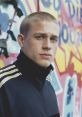 Pete Dunham from Green Street Hooligans with a determined look, against a vibrant graffiti backdrop.