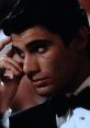 Manny Ribera from Scarface, deep in thought, showcasing intense emotion in a classic tuxedo setting.