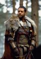 Maximus in Gladiator, wearing armor and a fur cloak, exudes strength and determination in a forest setting.