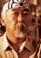 Mr. Miyagi, the wise mentor from The Karate Kid, conveying strength and wisdom with a focused expression and iconic headband.