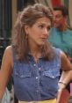 Rachel Green in a denim shirt with styled hair, giving a playful expression from the TV show Friends. Classic 90s fashion.