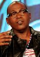 Randy Jackson discussing his role as a judge on American Idol, showcasing his signature style and engaging personality.