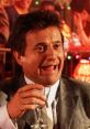 Tommy DeVito from Goodfellas enjoying a drink, showcasing his iconic, lively personality in a vibrant setting.