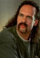 Character from "Office Space" with a striking mustache and long hair, capturing the film's quirky workplace vibe.