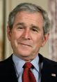 George W. Bush smiling in a formal setting, wearing a suit with a red tie, showcasing his approachable demeanor.