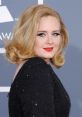 Adele at a glamorous event, showcasing her iconic hairstyle and red lipstick, captivating the audience with her elegance.