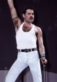 Freddie Mercury performing passionately on stage, wearing a white tank top and blue jeans, holding a microphone.