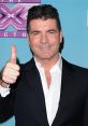 Simon Cowell giving a thumbs up at an X Factor event, showcasing his iconic style and confident demeanor.